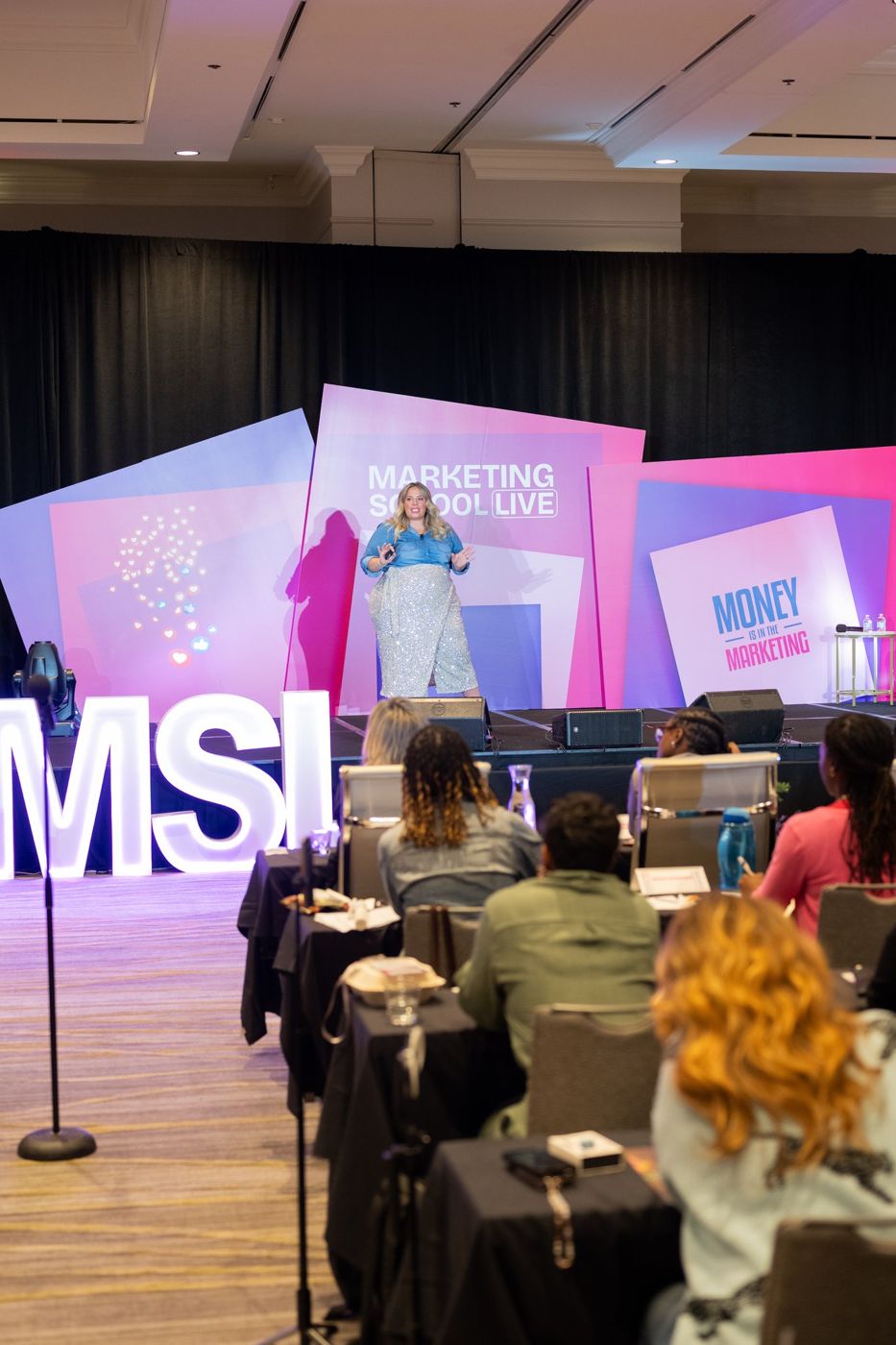 A speaker on stage in front of a full room