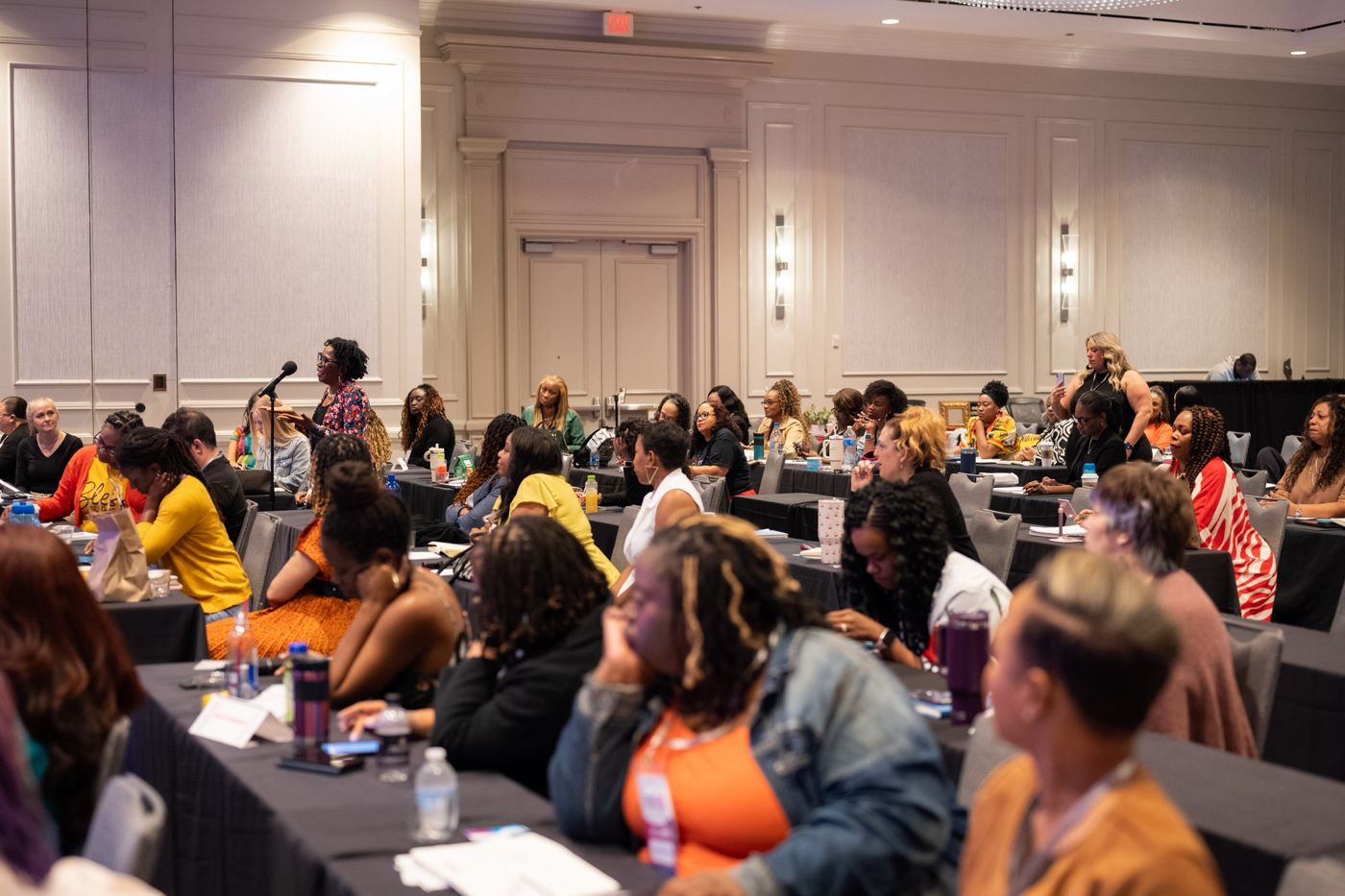 A packed room taking notes