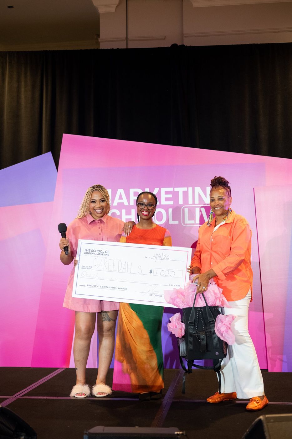 Aprille presenting the pitch winner check on stage